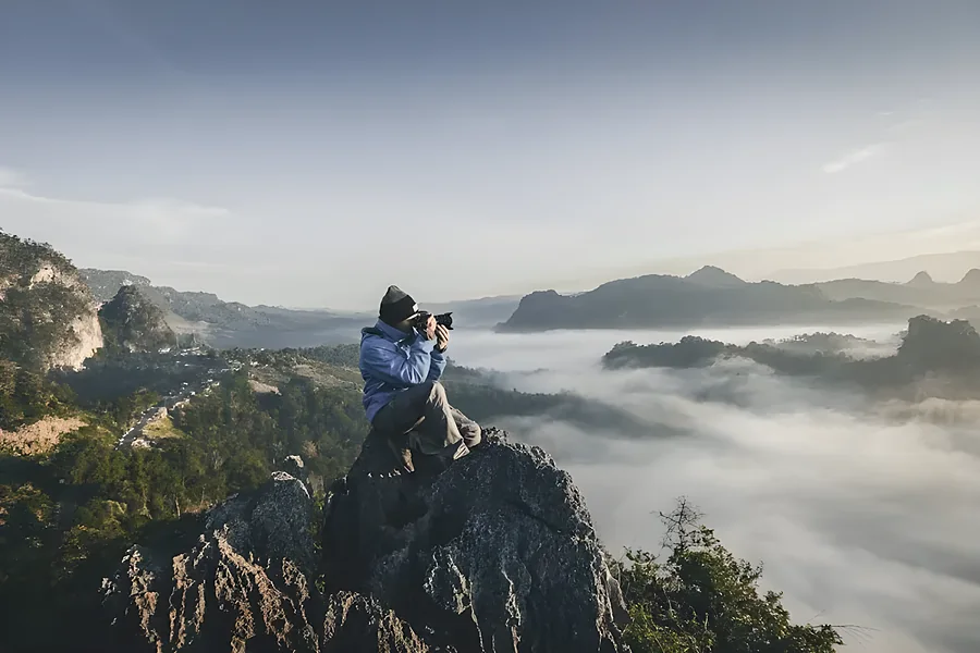 A climber on a rock above the fog