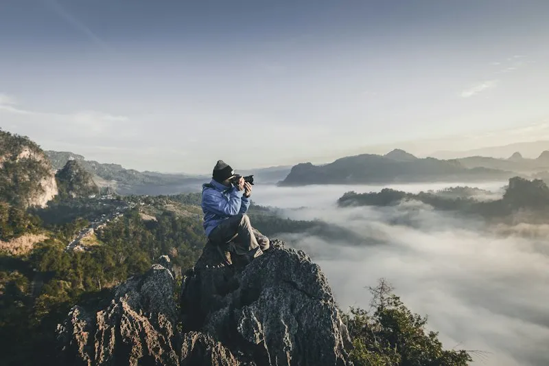 A climber on a rock above the fog