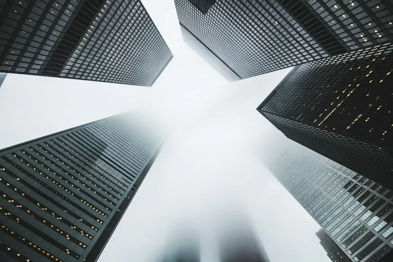 Looking straight up between glass office towers